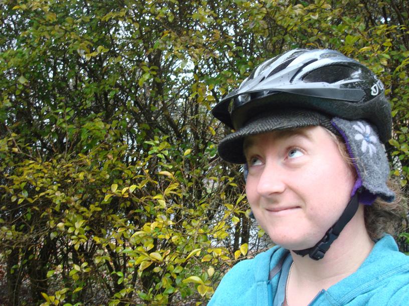 The author smiles wryly wearing a wool cycling cap under a helmet.
